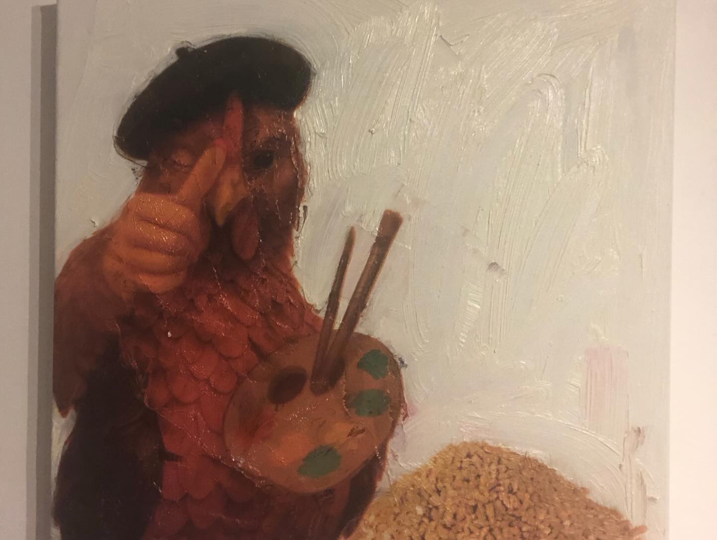 A colourful chicken-shaped artwork holding paintbrushes against a white wall