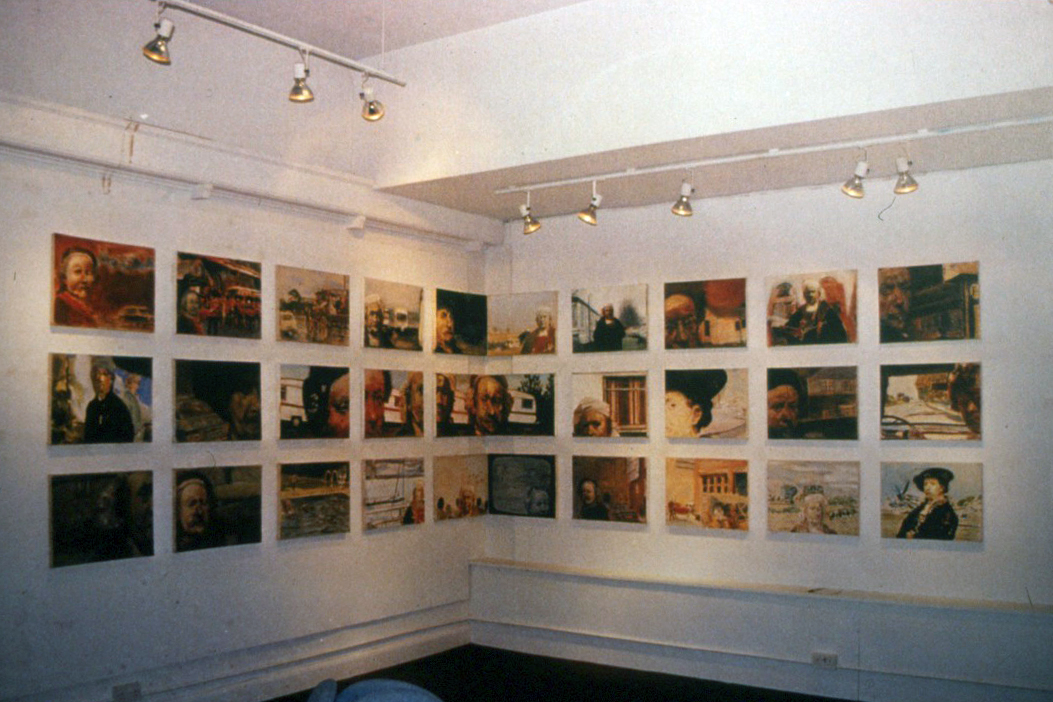 Paintings of Rembrandt among contemporary surroundings, installed in three rows across two gallery walls