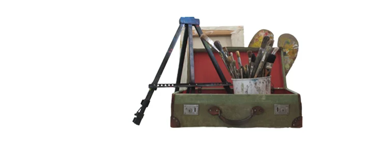 An open green suitcase containing brushes, palettes and a small easel